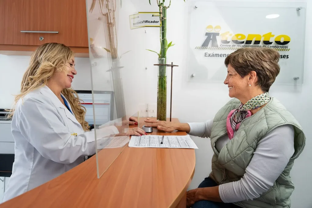 Paciente registrándose para examen médico con recepcionista de Atento IPS